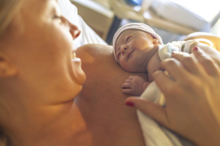 matka po pôrode s novorodencom v náručí v pôrodnici